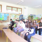 Uczeń odbiera nagrodę za aktywność podczas spotkania na temat segregacji i recyklingu odpadów.