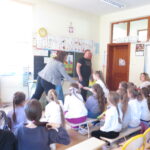 Uczennica odbiera nagrodę za aktywność podczas spotkania na temat segregacji i recyklingu odpadów.