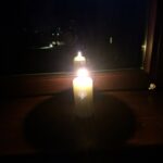 Zapalona świeca w oknie nocą – symbol pamięci o ofiarach stanu wojennego.