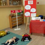 Ekspozycja dotycząca pierwszej pomocy z fantomami do ćwiczeń oraz materiałami edukacyjnymi.