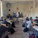 Uczniowie Szkoły Podstawowej nr 1 w Lubomierzu siedzą w klasie i oglądają na ekranie telewizora materiał o Powstaniu Warszawskim. Zdjęcie przedstawia zajęcia edukacyjne realizowane w ramach programu „BohaterON w Twojej Szkole 2026”