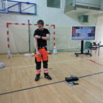 Ratownik demonstruje, jak należy używać opaski uciskowej w przypadku silnego krwawienia