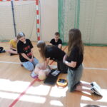 Uczniowie podzieleni na małe grupy, odgrywają scenki sytuacyjne, w których muszą wykonać resuscytację na fantomie i podłączyć AED