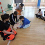 Uczniowie podzieleni na małe grupy, odgrywają scenki sytuacyjne, w których muszą wykonać resuscytację na fantomie i podłączyć AED