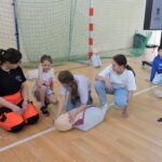 Uczniowie podzieleni na małe grupy, odgrywają scenki sytuacyjne, w których muszą wykonać resuscytację na fantomie i podłączyć AED