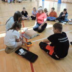 Uczniowie podzieleni na małe grupy, odgrywają scenki sytuacyjne, w których muszą wykonać resuscytację na fantomie i podłączyć AED