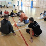 Uczniowie podzieleni na małe grupy, odgrywają scenki sytuacyjne, w których muszą wykonać resuscytację na fantomie i podłączyć AED