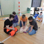 Uczniowie podzieleni na małe grupy, odgrywają scenki sytuacyjne, w których muszą wykonać resuscytację na fantomie i podłączyć AED