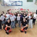 Uczniowie pozują do współnego zdjęcia z ratownikami po zakończonym kursie pierwszej pomocy