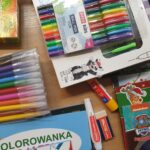 Kolorowe zestawy pisaków, długopisów i materiałów plastycznych przekazane w ramach akcji charytatywnej.