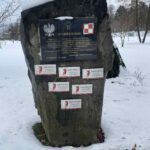 Czarna tablica pamiątkowa z godłem Polski, krzyżem i napisem „Non omnis moriar” poświęcona ofiarom katastrofy smoleńskiej.