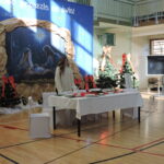 Scena z dekoracją bożonarodzeniową i stołem wigilijnym.