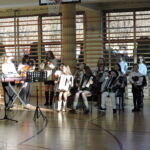 Uczniowie grają na instrumentach muzycznych podczas szkolnego występu świątecznego.