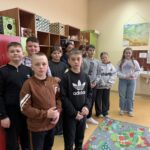 Grupa uczniów uczestniczących w szkolnym etapie konkursu „Góralskie Cytanie” stoi w sali lekcyjnej. W tle widoczne są półki z pomocami dydaktycznymi oraz umywalka.