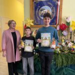 Nagrodzeni uczniowie z dyplomami i upominkami po wręczeniu nagród w konkursie na najpiękniejszą wielkanocną pisankę inspirowaną wiosną.