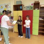 Wręczenie nagród laureatkom konkursu matematycznego „Olimpusek”. Nauczycielki przekazują uczennicom dyplomy i upominki za osiągnięte wyniki.