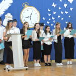 Uczniowie prezentują program artystyczny podczas zakończenia roku szkolnego.