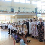 Uczniowie klas młodszych wraz z nauczycielami i pracownikami szkoły podczas uroczystej inauguracji roku szkolnego 2026/2027 w sali gimnastycznej